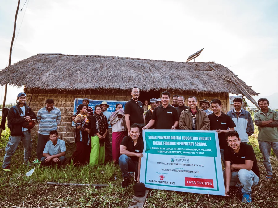 Team and community gathered outside the floating elementary school on Loktak Lake