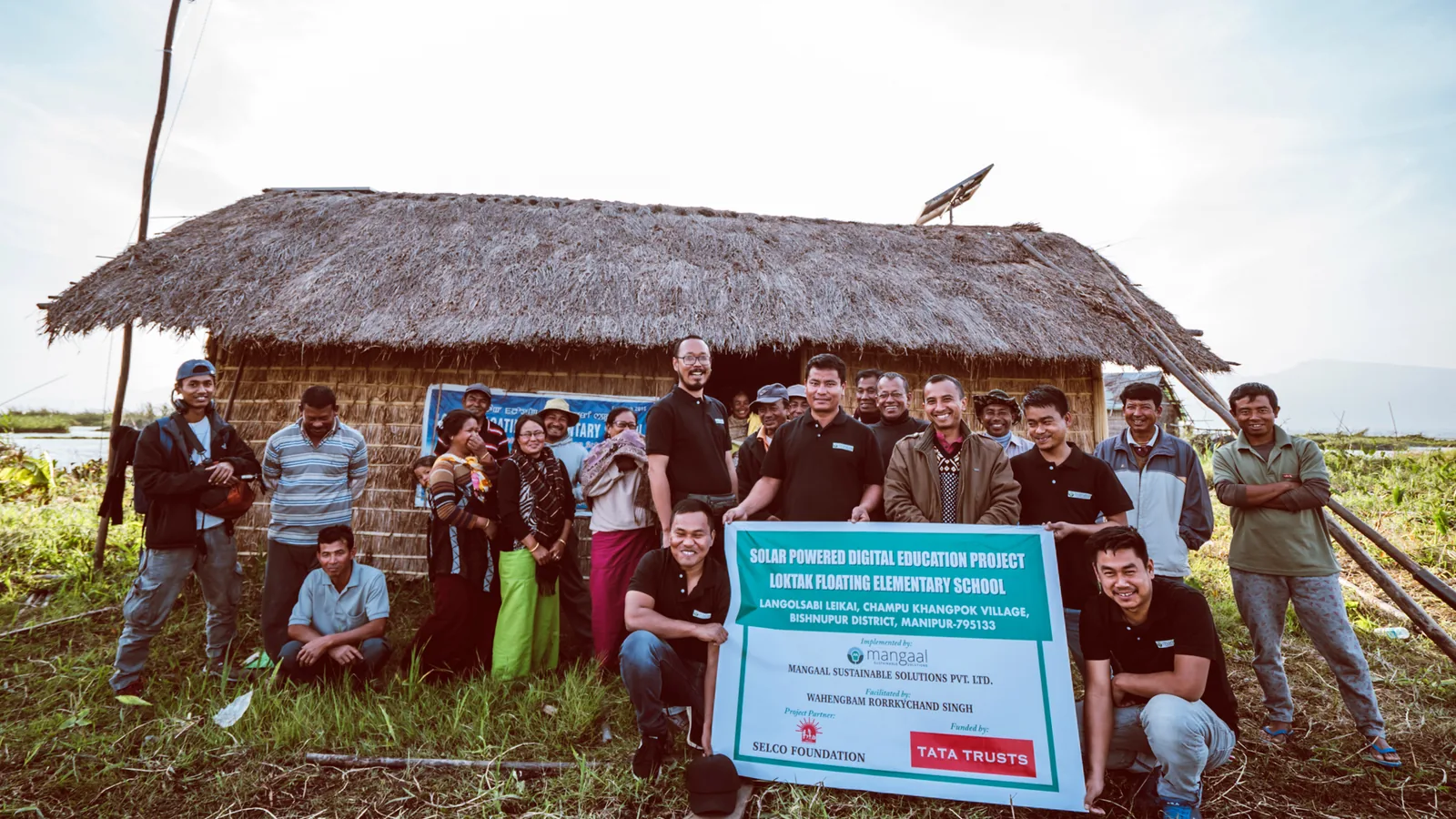 Team and community outside the Loktak floating elementary school at the project handover