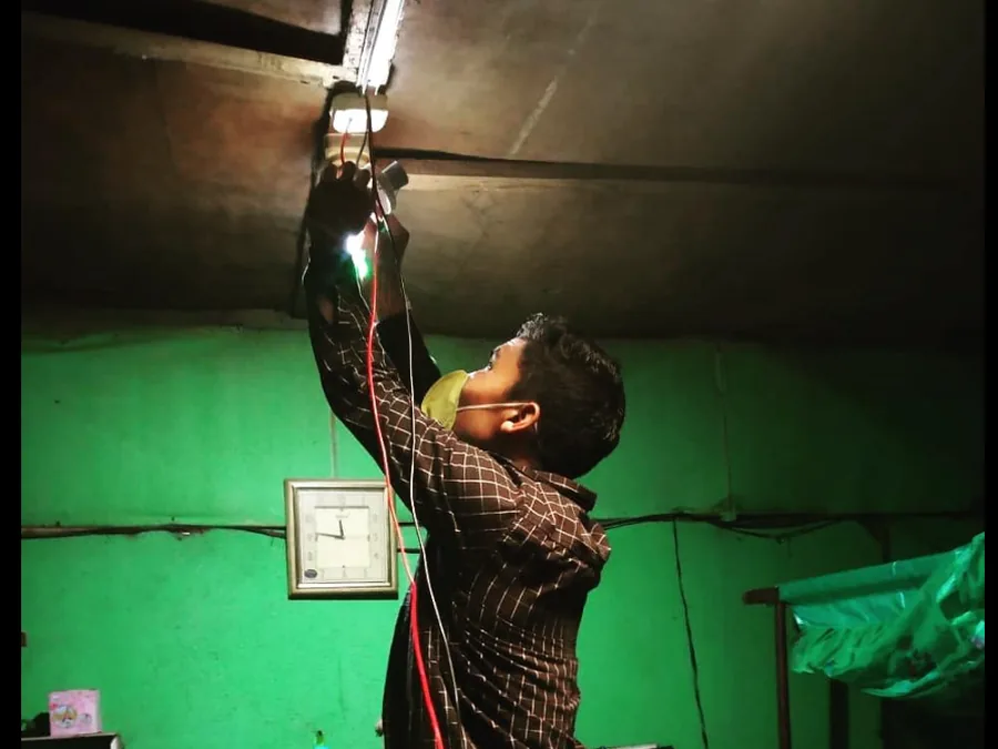 An Eartheners technician fitting a solar-powered light inside a rural home