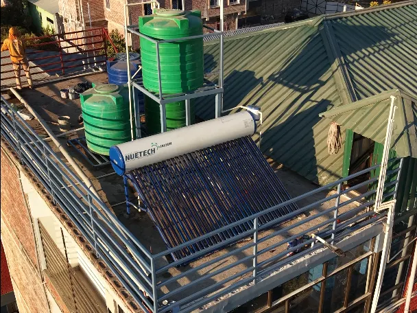 Solar water heater mounted alongside rooftop storage tanks in Manipur